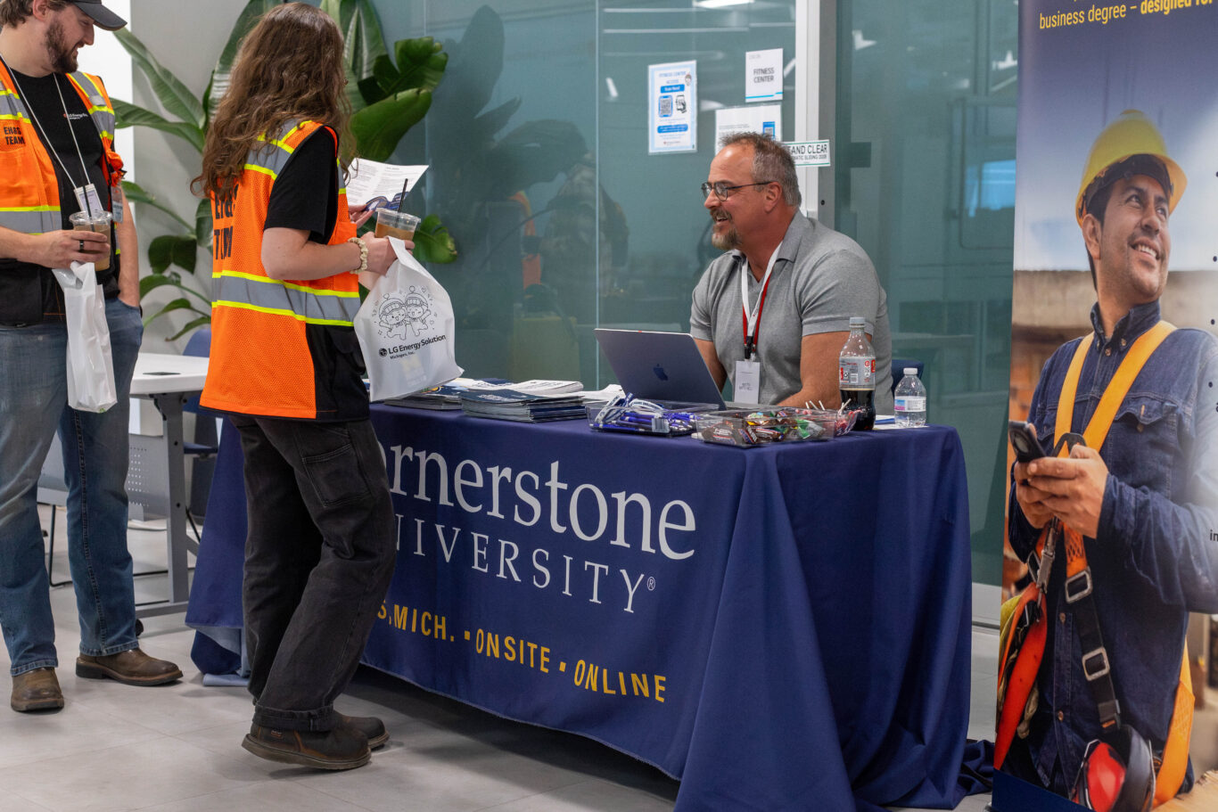 Team members talk with a Cornerstone University representative at the college fair. 